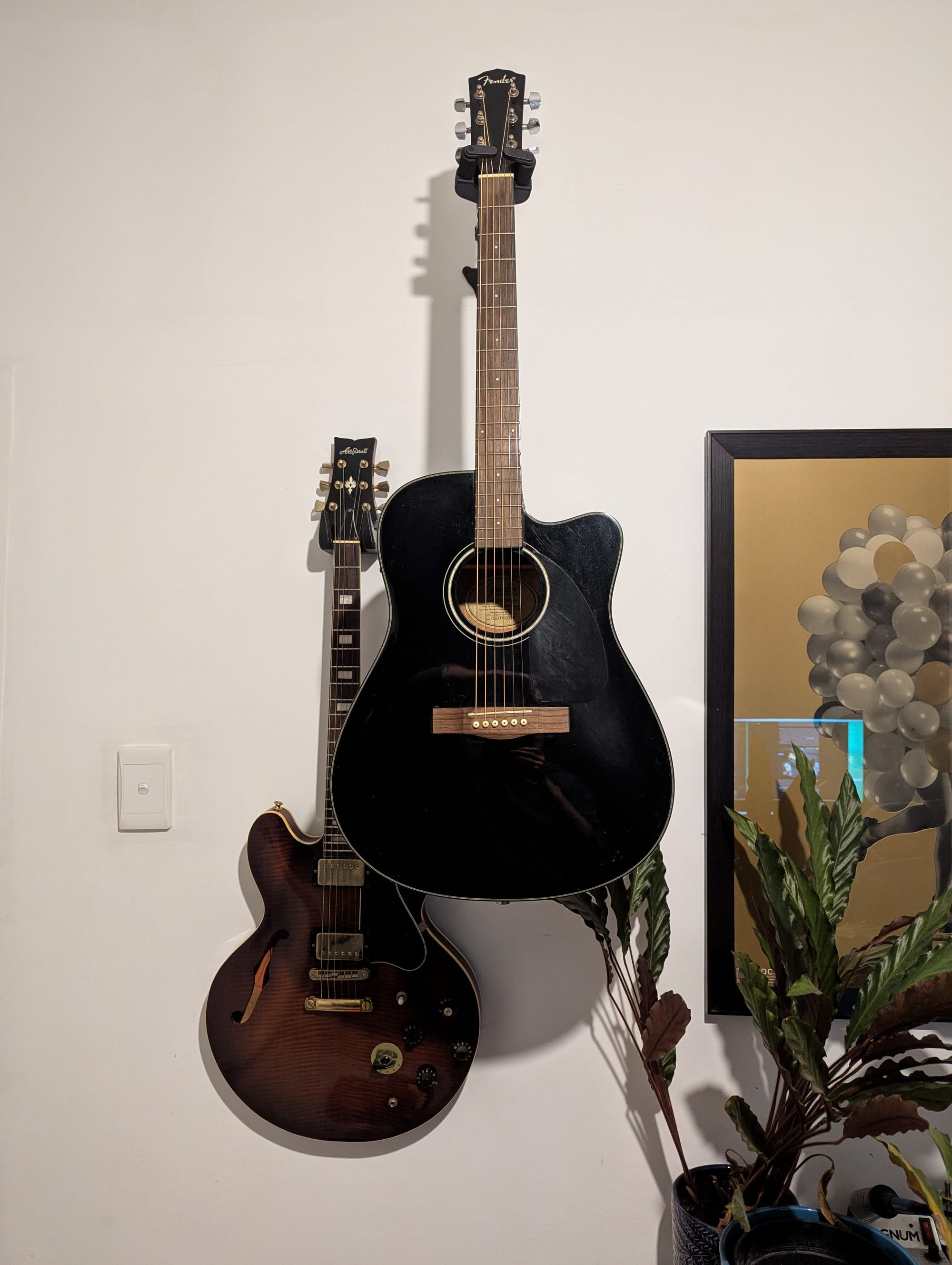 Two guitars mounted to the wall